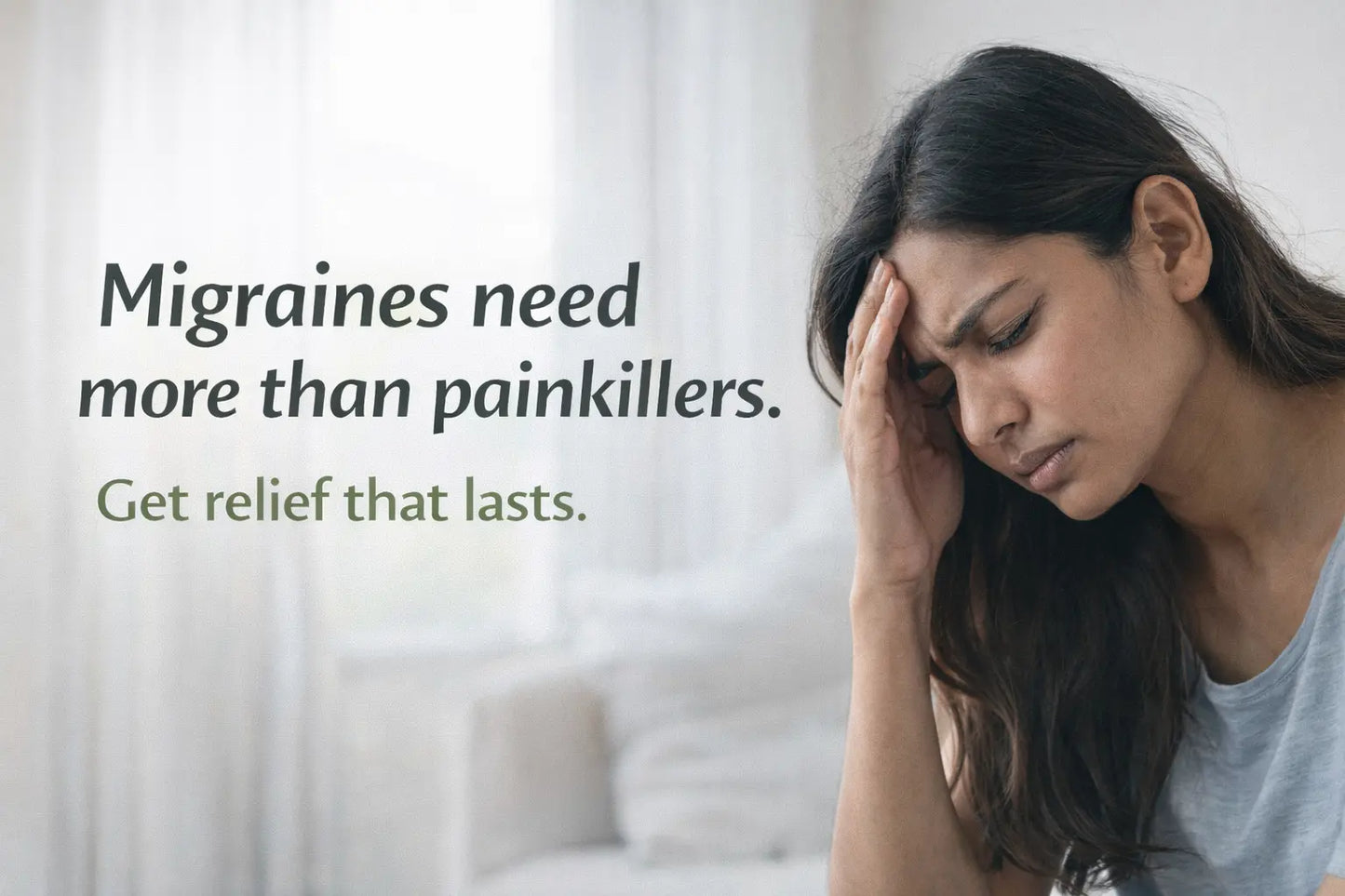 Indian person holding head in migraine pain with light sensitivity indoors